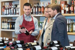 homme qui conseils ses clients sur une bouteille de vin